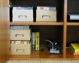 Use photo boxes to organize the media cabinet